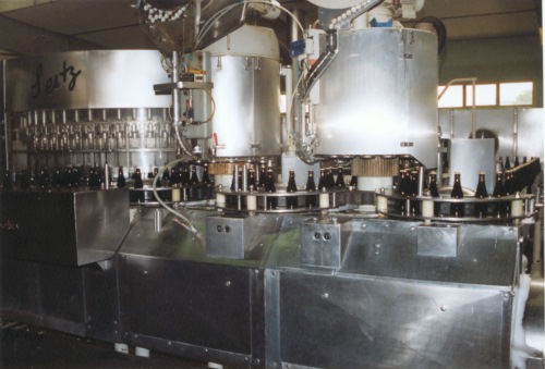 In dieser Maschine werden die sauberen Flaschen befüllt und mit einem Kronkorken verschlossen